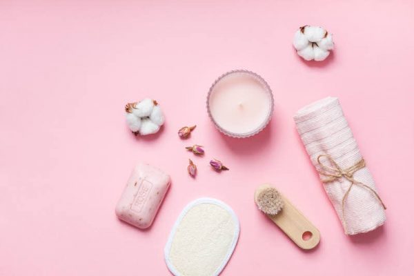 Spa, beauty cosmetics and body care treatment concept with copy space. Creative top view flat lay composition with bath accessories, organic rose soap on pink background